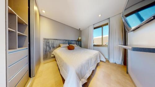 um pequeno quarto com uma cama e uma televisão em Liniers Green Apartments em Chacras de Coria