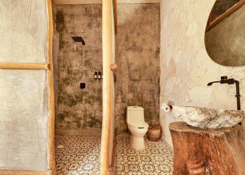 a bathroom with a toilet and a sink at Alquimia Hotel Boutique in Tulum