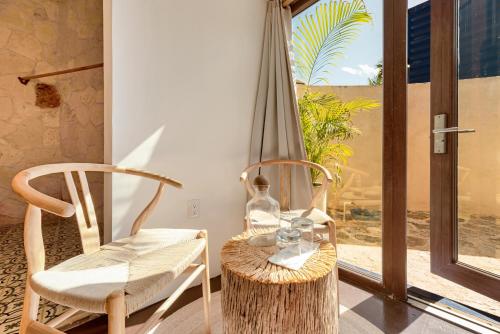 a room with a table and chairs and a window at Alquimia Hotel Boutique in Tulum