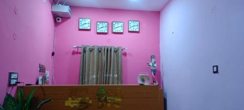 a room with a pink wall with a mirror at Govind Niwas Homestay in Jagdalpur