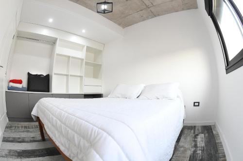 a bedroom with a large white bed with a window at Depto. en Costanera frente al rio 2 a 4 personas in San Nicolás de los Arroyos