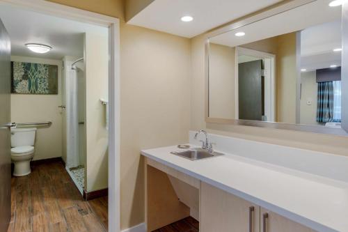 a bathroom with a sink and a mirror and a toilet at Best Western Plus South Coast Inn in Santa Barbara