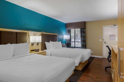 two beds in a hotel room with blue walls at Best Western Plus South Coast Inn in Santa Barbara