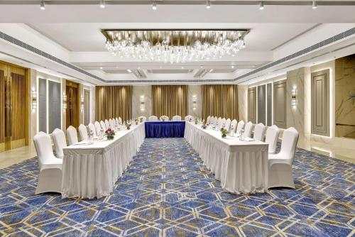 a large banquet room with white tables and white chairs at Park Inn by Radisson Surat in Surat