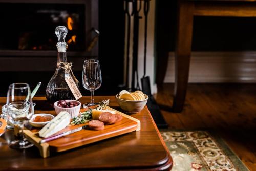 a table with a plate of food and glasses of wine at Amberesque B&B in Rutherglen