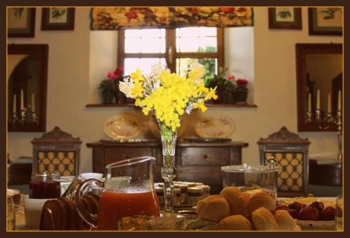a table with a vase of yellow flowers and food at Castello Di Strambinello in Strambinello