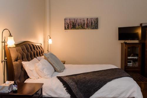 1 dormitorio con cama, mesa y TV en Amberesque B&B, en Rutherglen