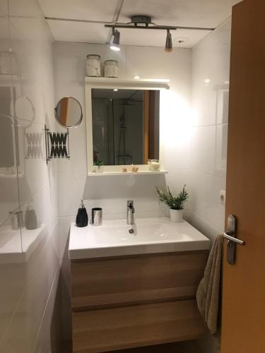 y baño con lavabo blanco y espejo. en Designer's Flat - 3 Bdrm - Wifi - Best Location, en Alicante