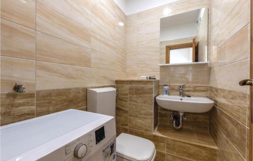 a bathroom with a sink and a toilet and a mirror at 4 Bedroom Cozy Home In Otok in Otok