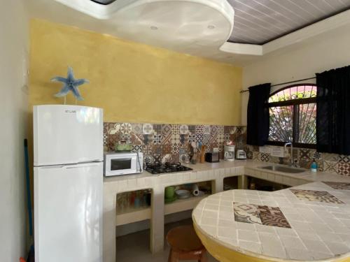 a kitchen with a white refrigerator and a table at Casa Maiana in Sámara