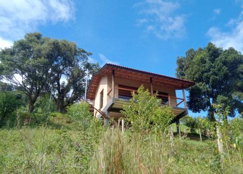 a house on a hill with trees in the background at Sonho na Serra Chalé 2 in Gonçalves
