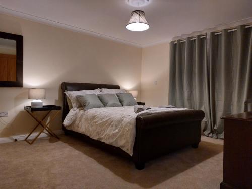 a bedroom with a bed and a lamp and curtains at The Cove in Aughnacloy