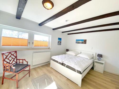 a bedroom with a bed and a chair in it at Reethaus Vilmnitz Reethaus Vilmnitz - Fewo "Muglitz" in Vilmnitz