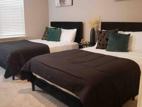 a bedroom with two beds with brown and green pillows at The Lavish Experience 2Bed/2Bathroom W/Pool in Houston