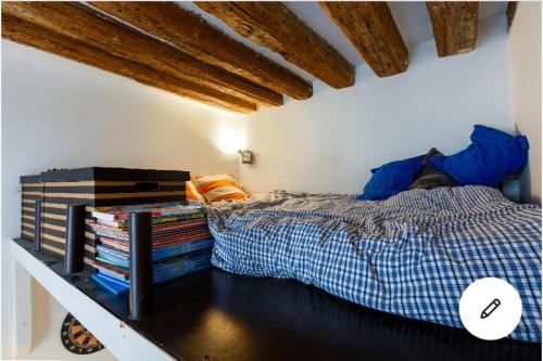 1 dormitorio con 1 cama en una habitación con techos de madera en Appartement Panthéon, en París