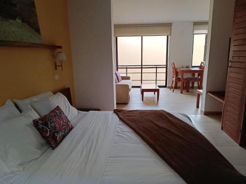 a bedroom with a bed with a pillow on it at Hotel Boutique Confort Suites in Popayan