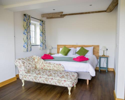 a bedroom with a bed and a couch at The Stables and The Tackroom at Castle Chase, Ayston 