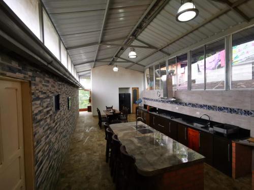 a kitchen with a counter and a brick wall at CASA DE CAMPO CORRALEJAS - ANOLAIMA in Anolaima