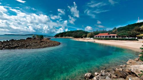 een uitzicht op een strand met een huis in de verte bij Coralview Island Resort in Tavewa