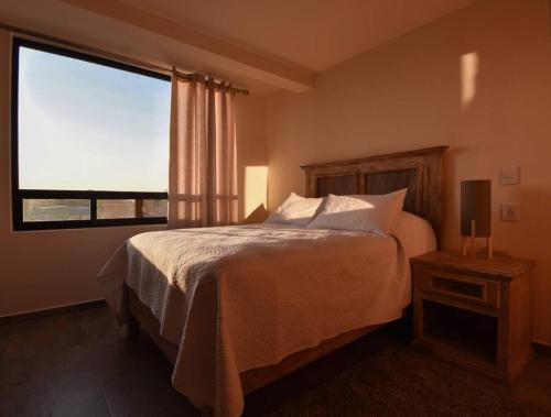 聖胡安特奧蒂瓦坎的住宿－Lofts Teotihuacan, Departamento 3，一间卧室设有一张床和一个大窗户