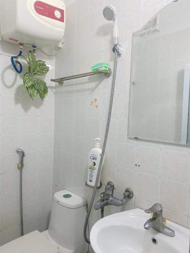 a bathroom with a toilet and a sink and a mirror at Cuccu homestay in Kiến An