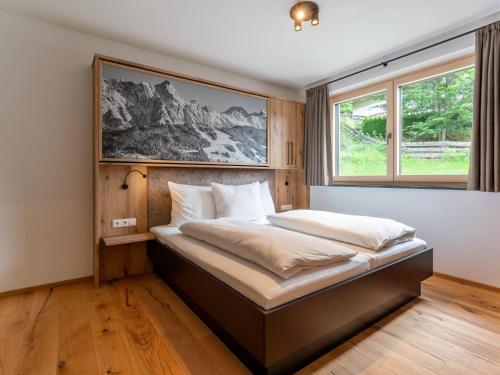 a bed in a bedroom with a large window at Schmittenblick 2 in Viehhofen