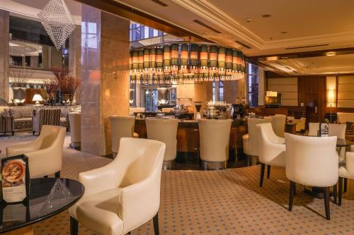 a restaurant with white chairs and a bar at Sheraton Ankara Hotel & Convention Center in Ankara