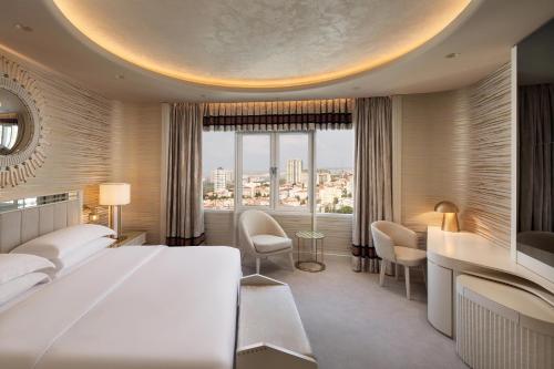 a bedroom with a large bed and a large window at Sheraton Ankara Hotel & Convention Center in Ankara
