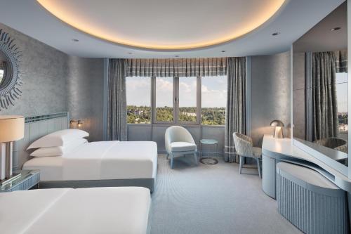 a hotel room with two beds and a desk at Sheraton Ankara Hotel & Convention Center in Ankara