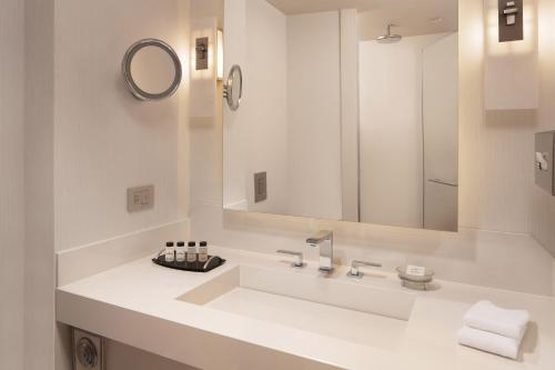 a white bathroom with a sink and a mirror at Sheraton Ankara Hotel & Convention Center in Ankara