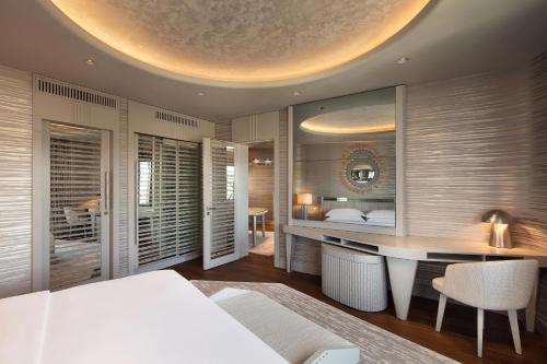 a bedroom with a white bed and a desk and a room with a bedzinski at Sheraton Ankara Hotel & Convention Center in Ankara