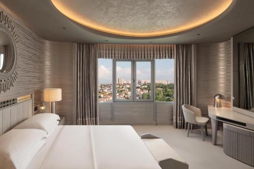 a bedroom with a large white bed and a desk at Sheraton Ankara Hotel & Convention Center in Ankara
