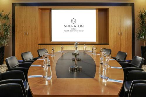 a conference room with a table and chairs and a screen at Sheraton Ankara Hotel & Convention Center in Ankara
