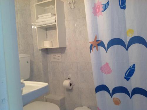 a bathroom with a toilet and a shower curtain at Travlos Studios in Póros Kefalonias