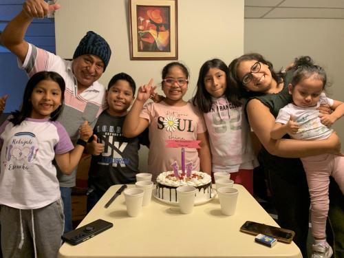a group of people standing around a table with a birthday cake at Hotel Acuario in Churín