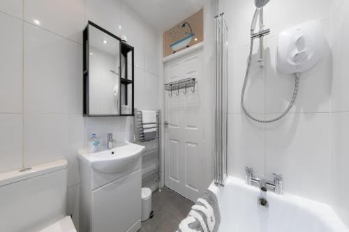 a white bathroom with a sink and a shower at Stunning house near Blackpool attractions in Blackpool
