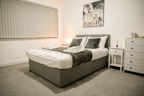 a bedroom with a large bed and a dresser at Luxury 2 bedroom apartment in Birmingham