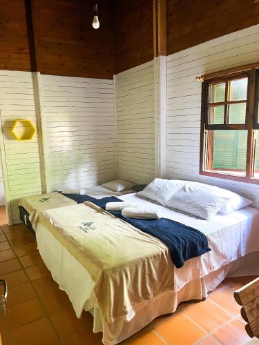 a bedroom with two beds in a room at Pousada Recanto das Hortênsias in Cunha