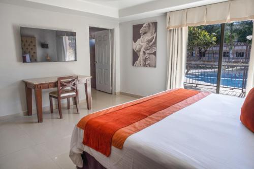 a bedroom with a bed and a desk and a window at Hotel Santorian in Hermosillo