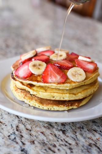 a stack of pancakes with strawberries and bananas on a plate at Hotel Santorian in Hermosillo
