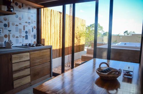 uma cozinha com uma mesa de madeira e uma banheira em Vila Astra - jacuzzi privativa, natureza e conforto em Alto Paraíso de Goiás
