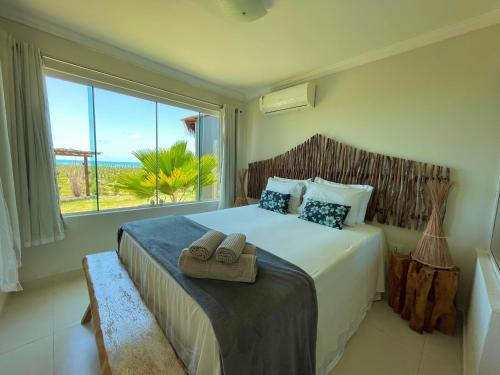 a bedroom with a large bed with a large window at Chalés Alto dos Milagres in São Miguel dos Milagres