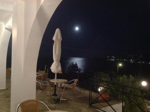 a patio with a table and chairs at night at Travlos Studios in Póros Kefalonias