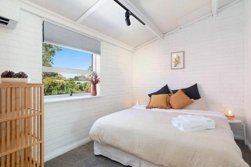 a bedroom with a large bed and a window at Stylish, comfortable and pet friendly home in the heart of Kensington in Norwood