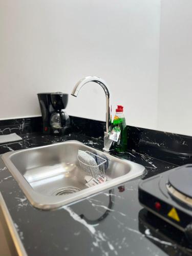 a kitchen sink with a basket in it at Hotel Boutique Business Center in Cali