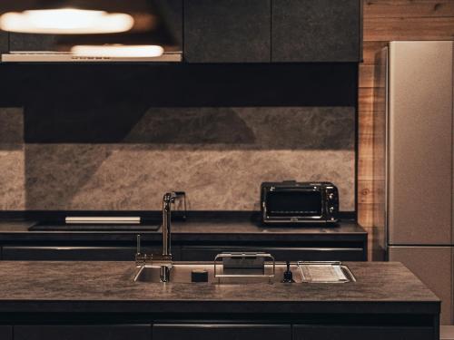 a kitchen with a sink and a toaster oven at Hygge Chalet Hakuba in Hakuba