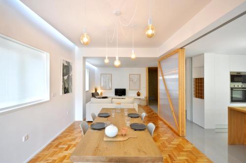 a dining room with a table and a living room at Casa do Bieira for Family By Sé Apartamentos in Braga