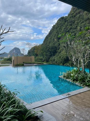 a swimming pool with a mountain in the background at Onsen Suits HJM @ Sunway Ipoh in Ipoh