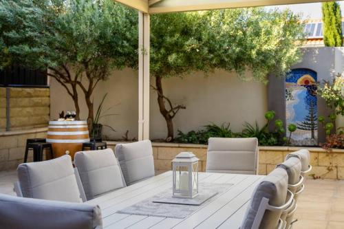 a white table and chairs on a patio at Christies Breeze a luxurious getaway by the sea in Christies Beach