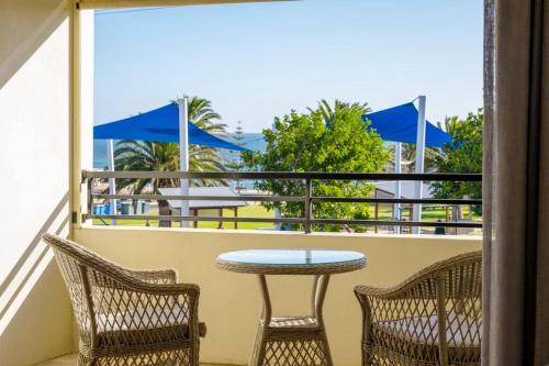 a balcony with a table and chairs and a table at Christies Breeze a luxurious getaway by the sea in Christies Beach